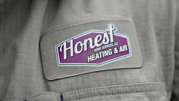 grey work shirt with a honest logo on it